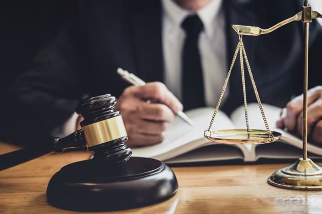 Lawyer working on a contract with scales and gavel