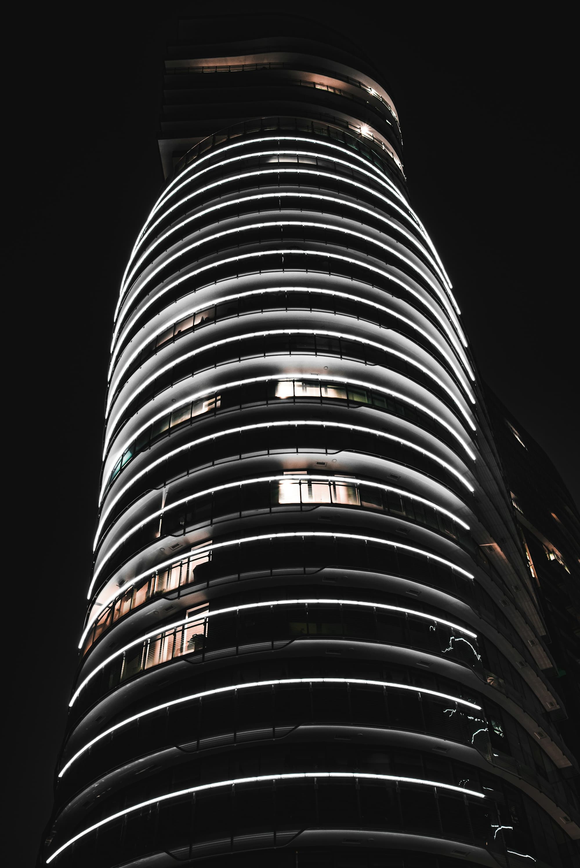 Curved office tower lit at night